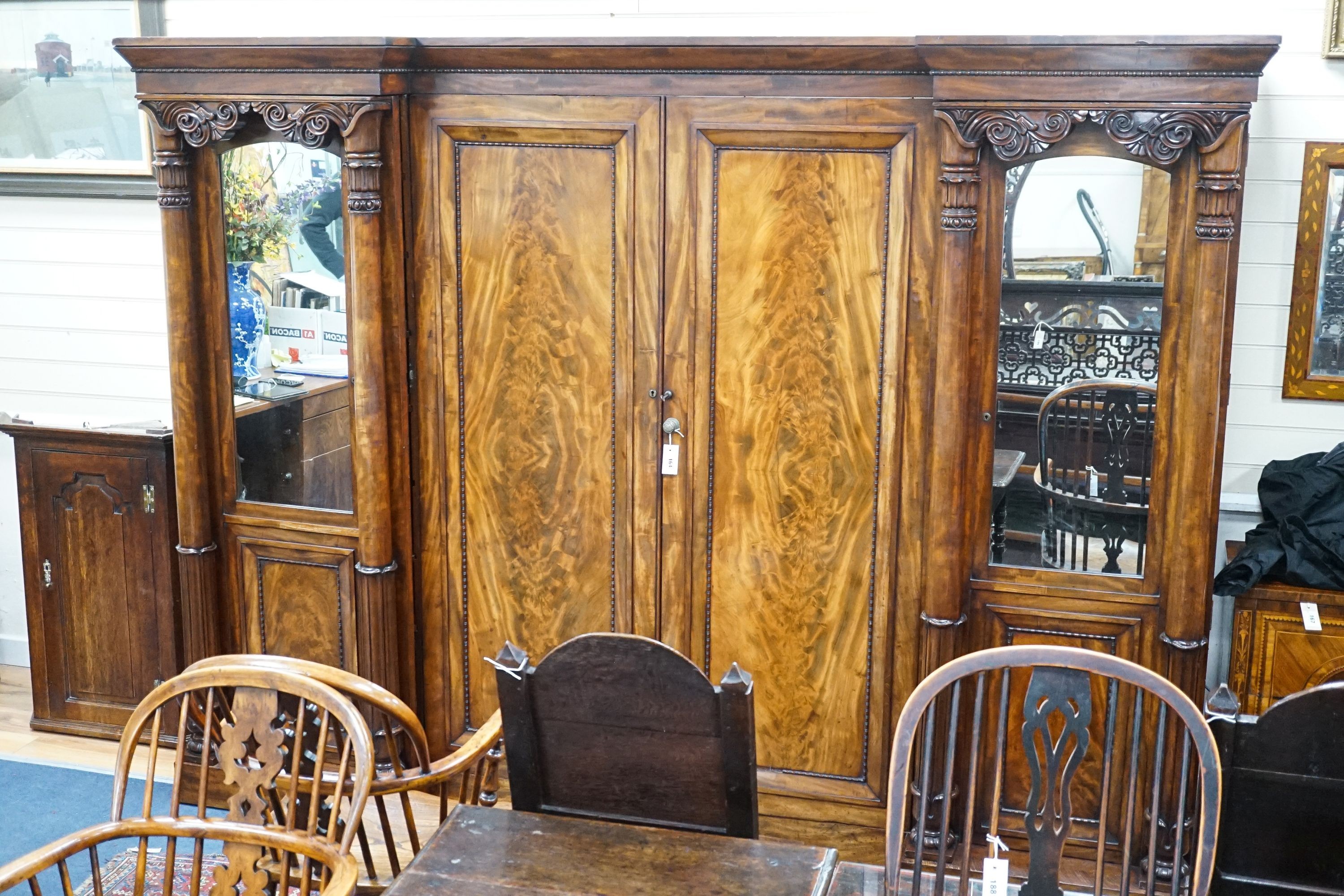 A William IV figured mahogany inverse breakfront compactum wardrobe, length 263cm, depth 70cm, height 197cm